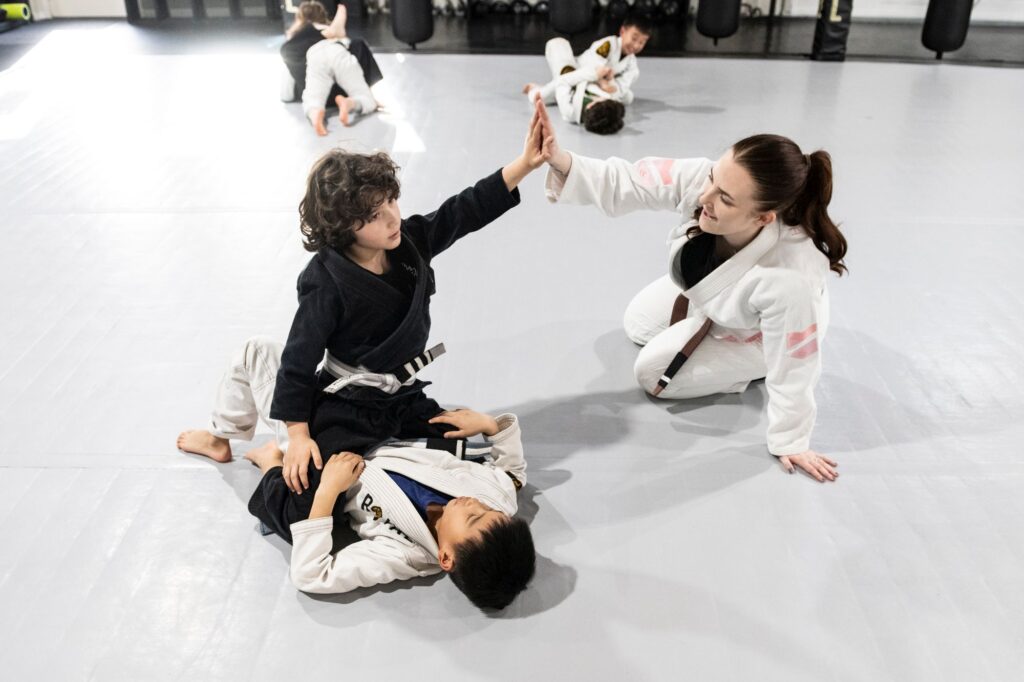 Royal Mixed Martial Arts instructor high fiving sparring winner at kids jiu jitsu class