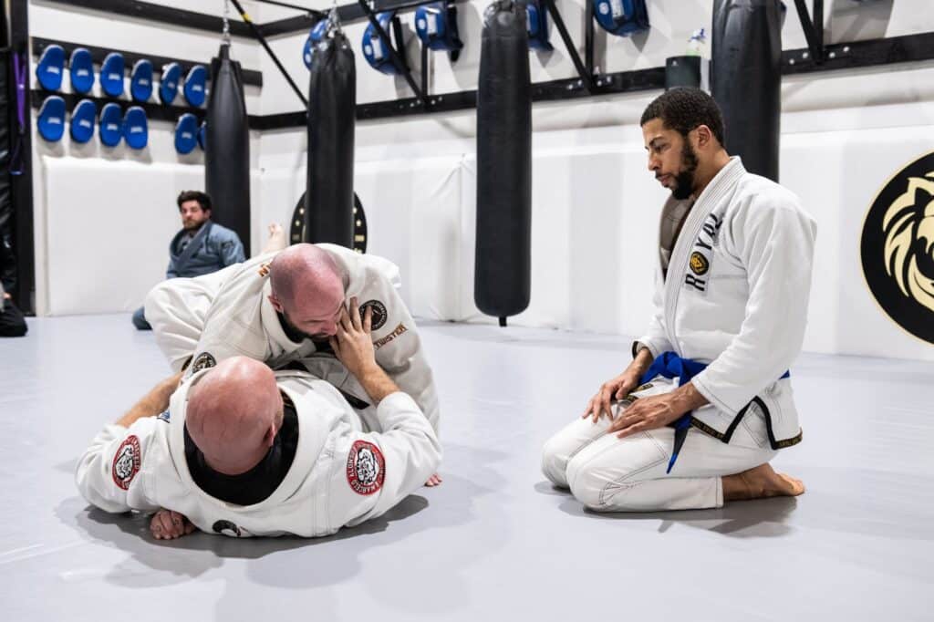 instructor demonstrating proper jiu jitsu techniques with Royal Mixed Martial Arts students watching demonstration